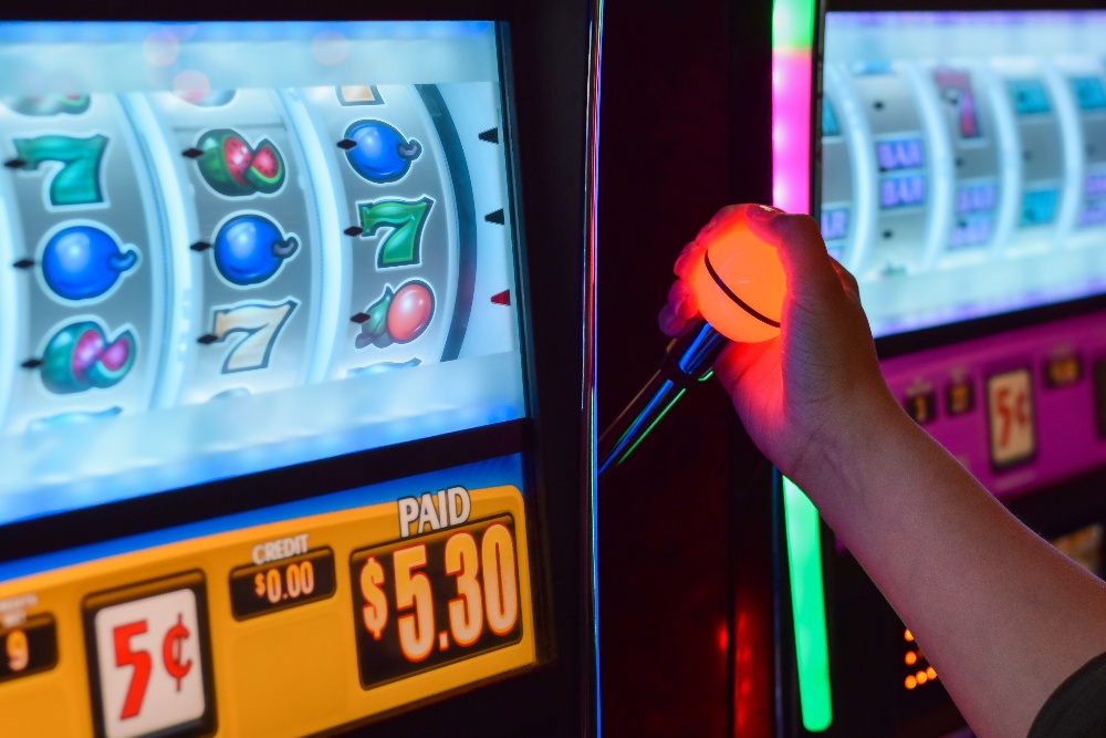 female-hand-arm-playing-slot-machine-at-casino-2022-11-15-13-19-39-utc-1