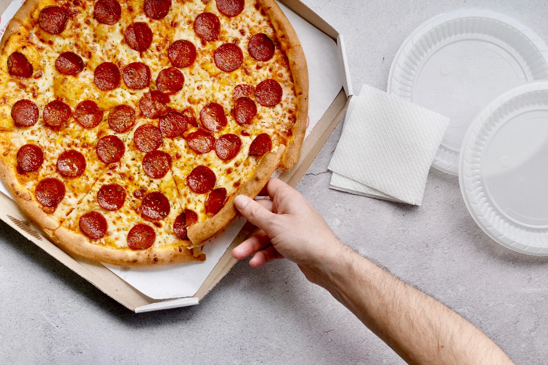 person-holding-a-slice-of-pepperoni-pizza-2022-11-08-07-47-39-utc2-1
