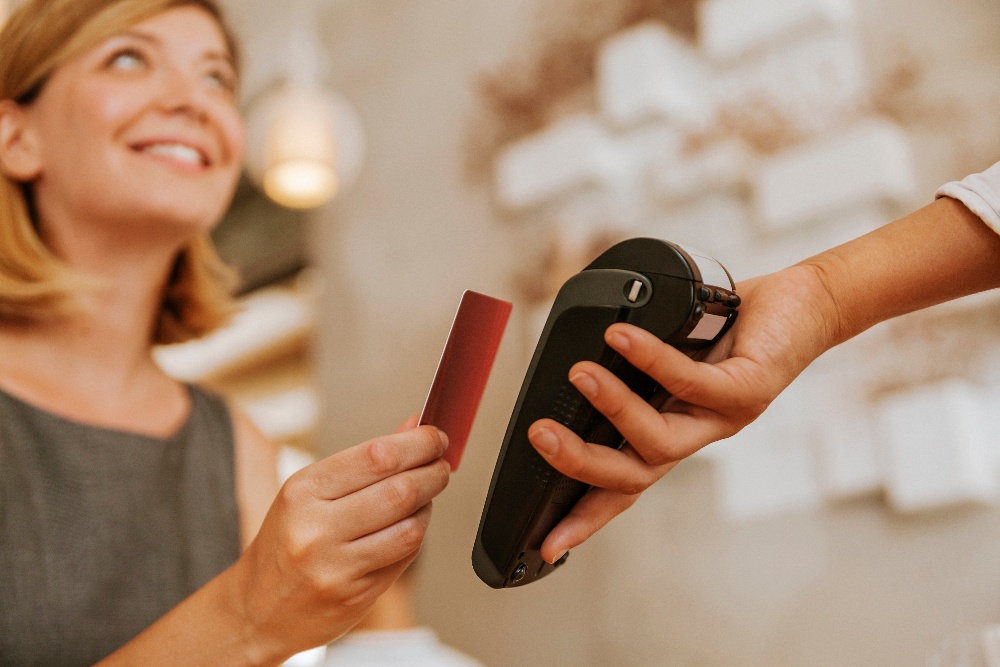smiling-woman-paying-contactless-in-cafe-2023-11-27-05-09-03-utc-1